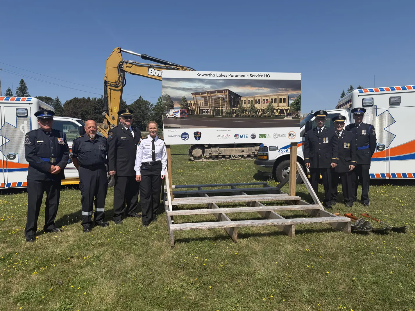 Paramedic HQ groundbreaking ceremony attendees posing with sign