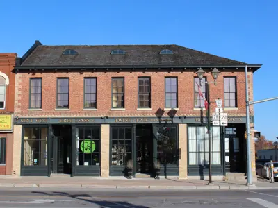 Street view of a historic red brick building, with bright blue sky in the background.