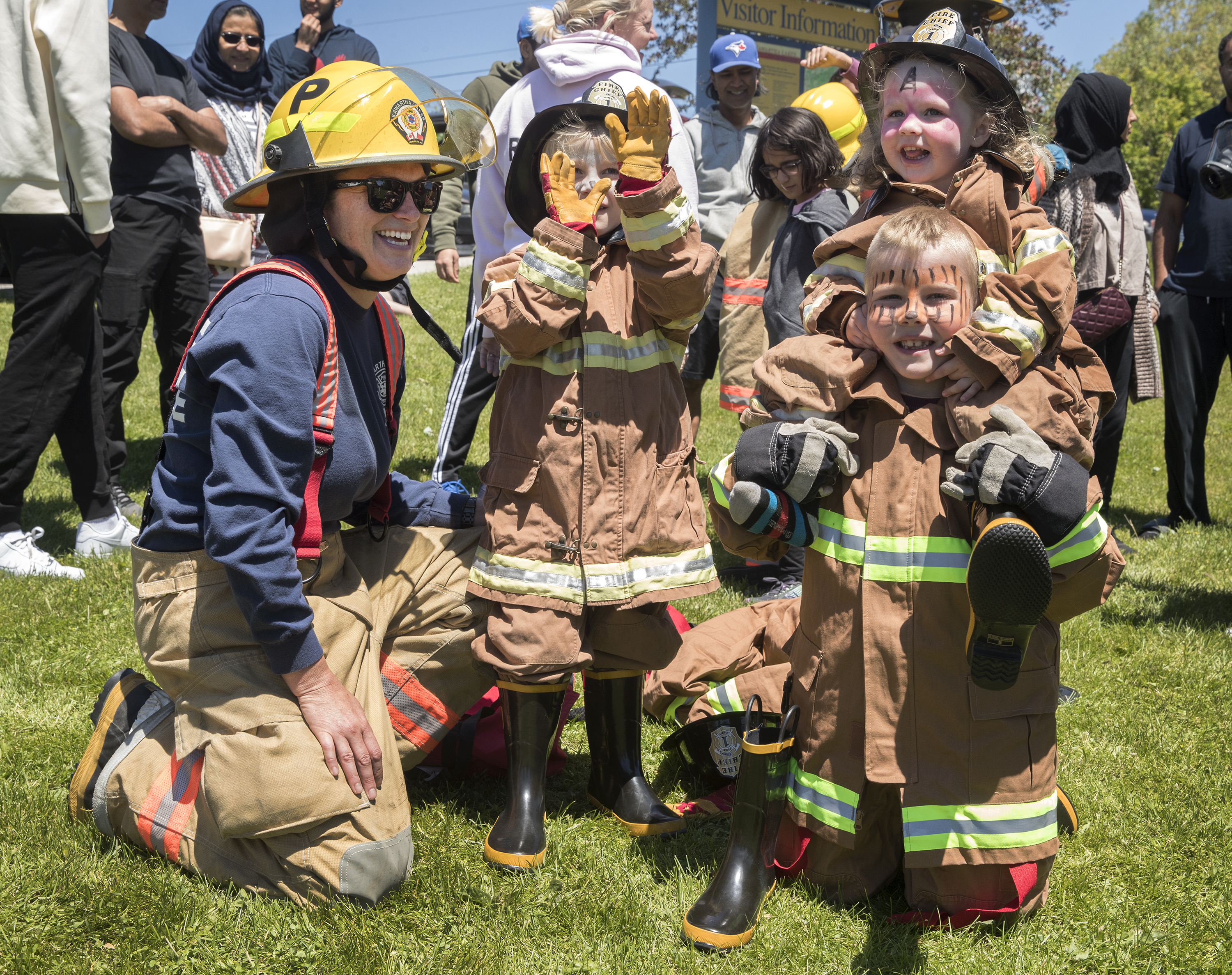 kids trying on firefighter uniforms
