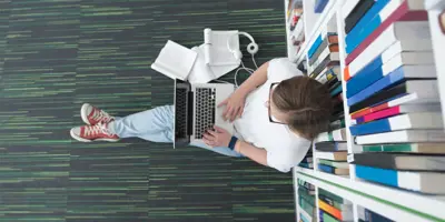 View of women working on laptop in library
