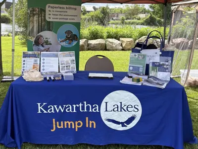 Photo of an information booth set up outdoors under a canopy.