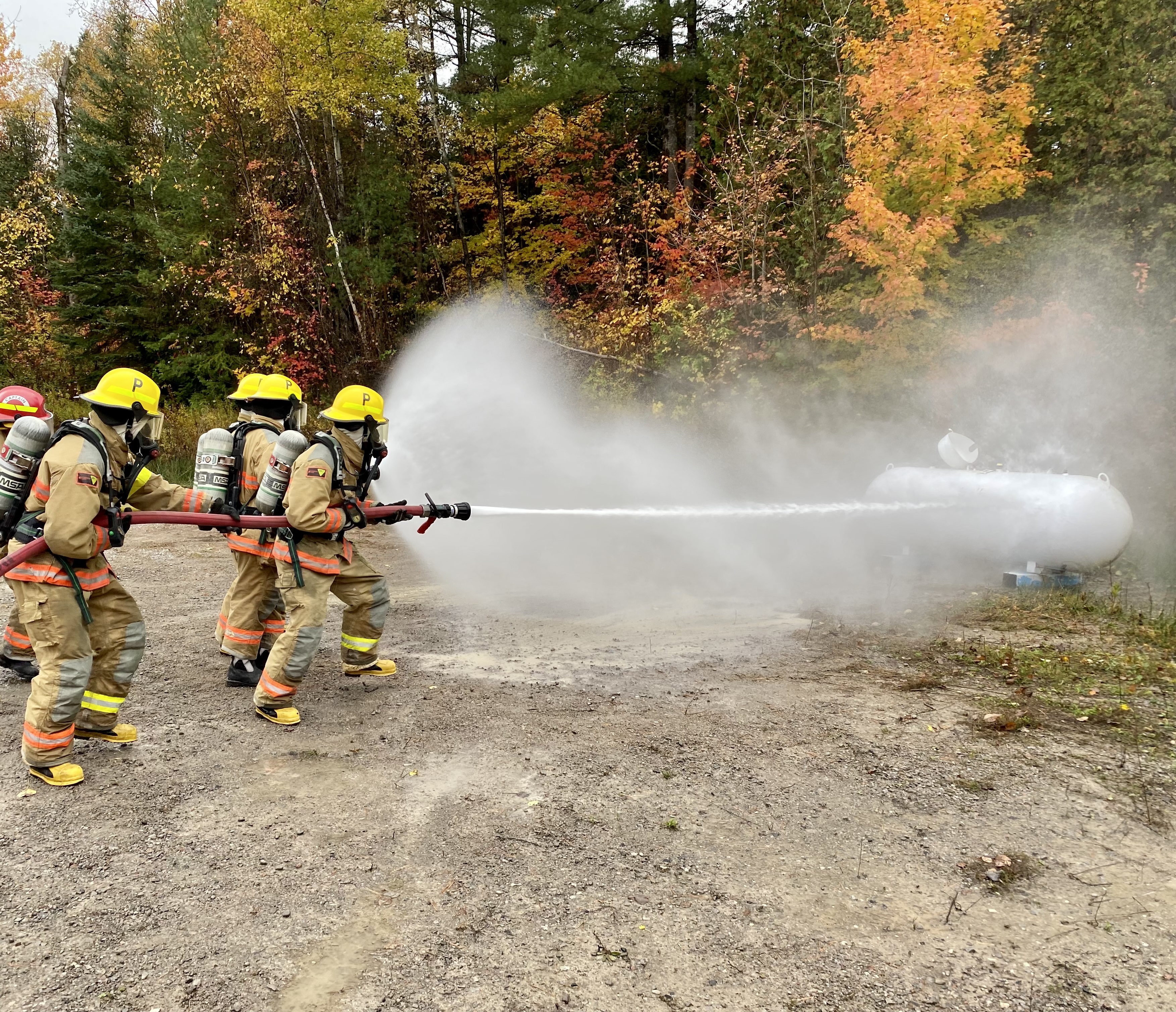 Group of firefighters using hose to fight a fire