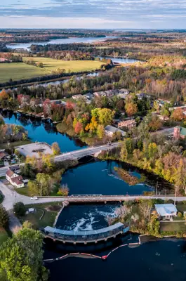 Aerial view of river with multiple bridges overtop and town buildings and houses surrounding the town