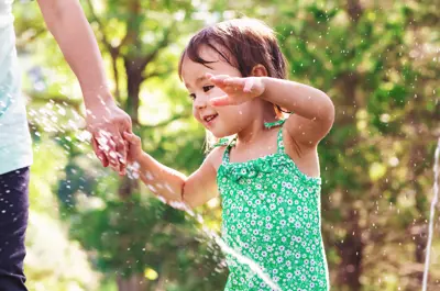 Child smiling and playing in water