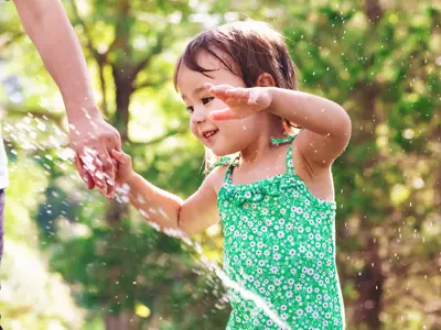 Child smiling and playing in water