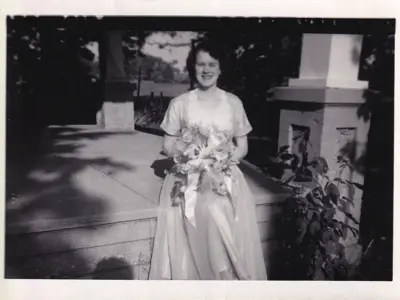 Black and white photo of woman in wedding dress holding a bouquet.