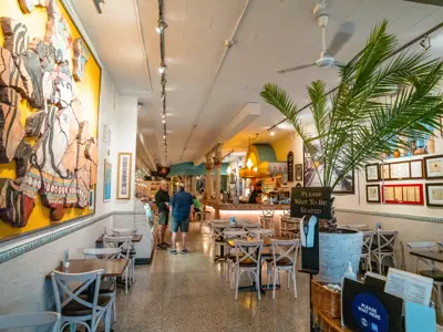 Interior of a cafe with yellow walls and chairs and tables set up