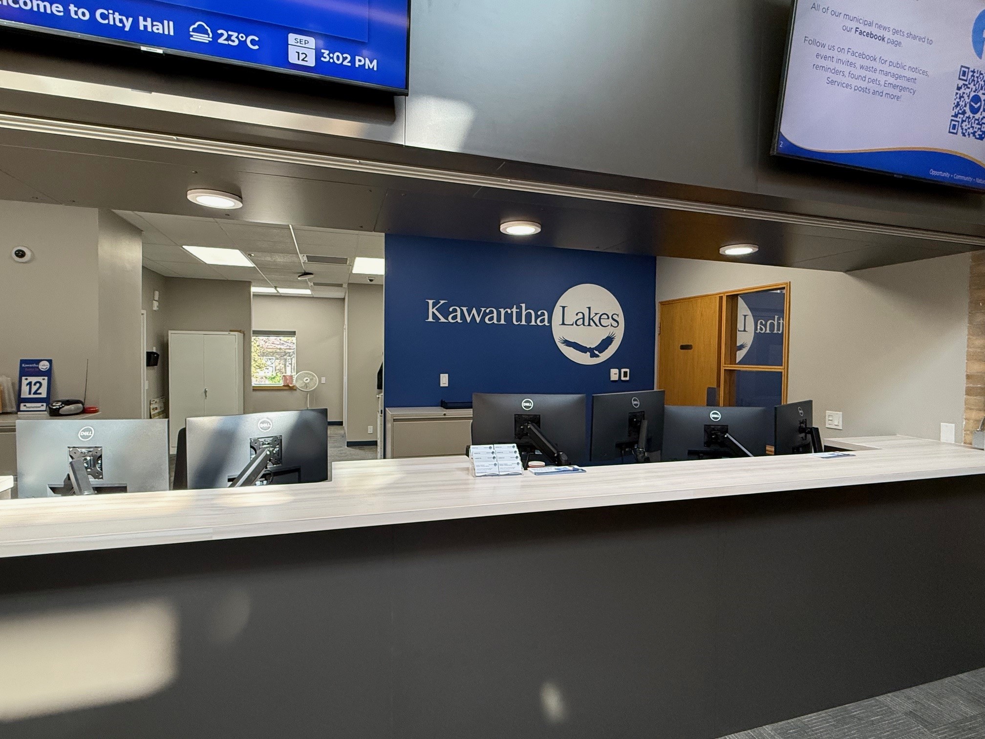Picture of an empty service desk with a large digital billboard in the background