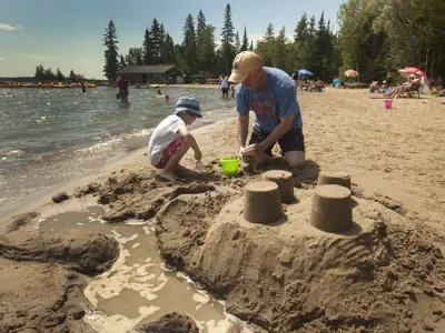 Man and child building a sand castle on a beach front