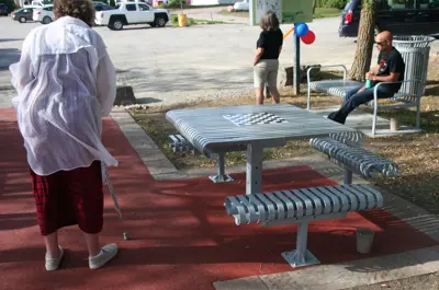 Game board picnic table with a woman walking nearby
