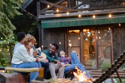 group playing guitar around a campfire